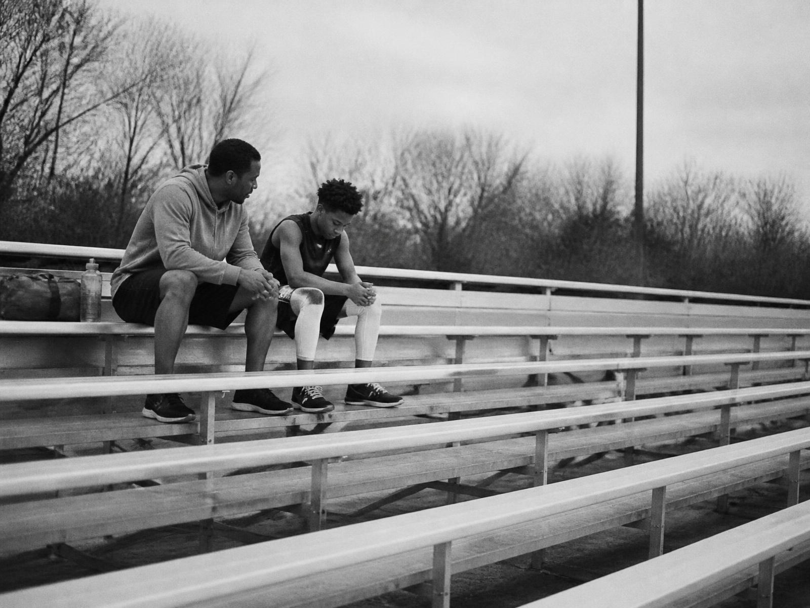 A parent listening to their athlete on empty bleachers